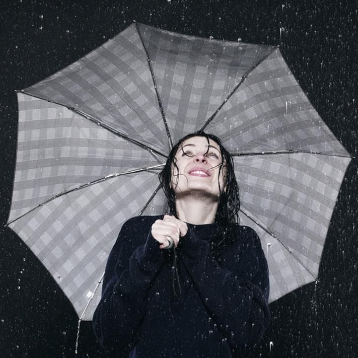 Frau mit Schirm im Regen